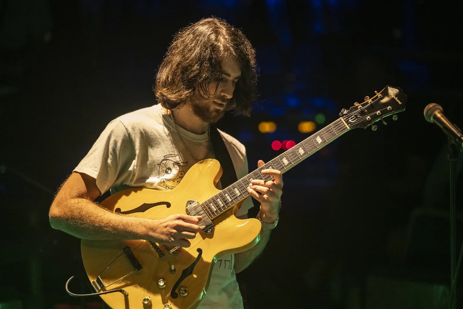 Warren Galea performing on a yellow hollow-body guitar