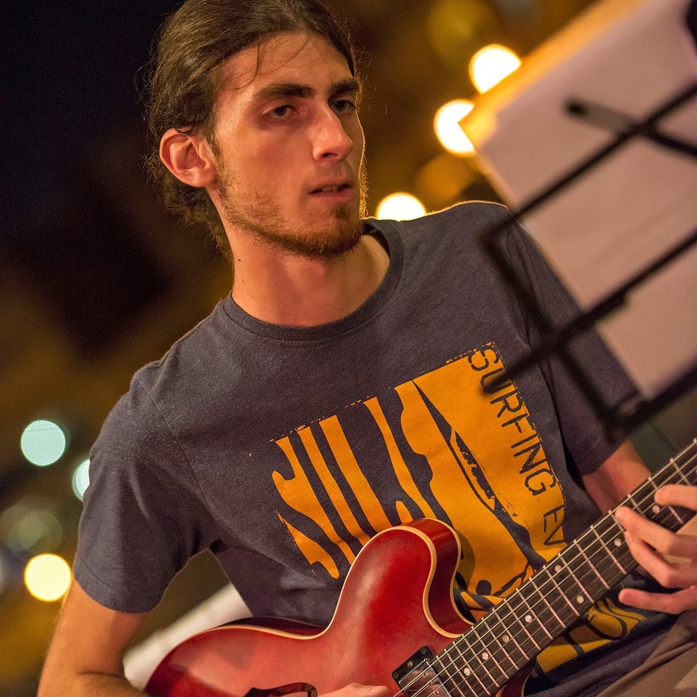 Close-up of Warren Galea playing a red guitar