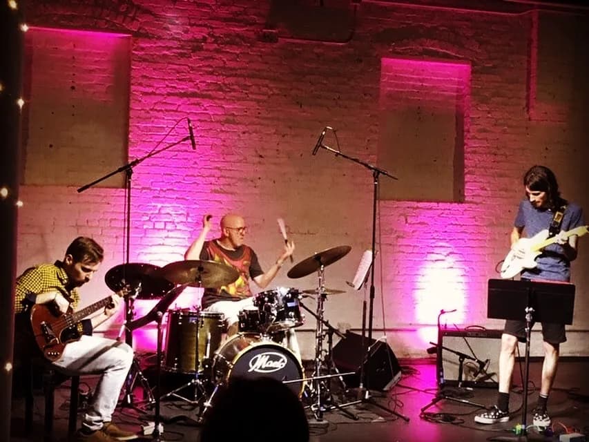 Jazz ensemble performing in a pink-lit concert hall