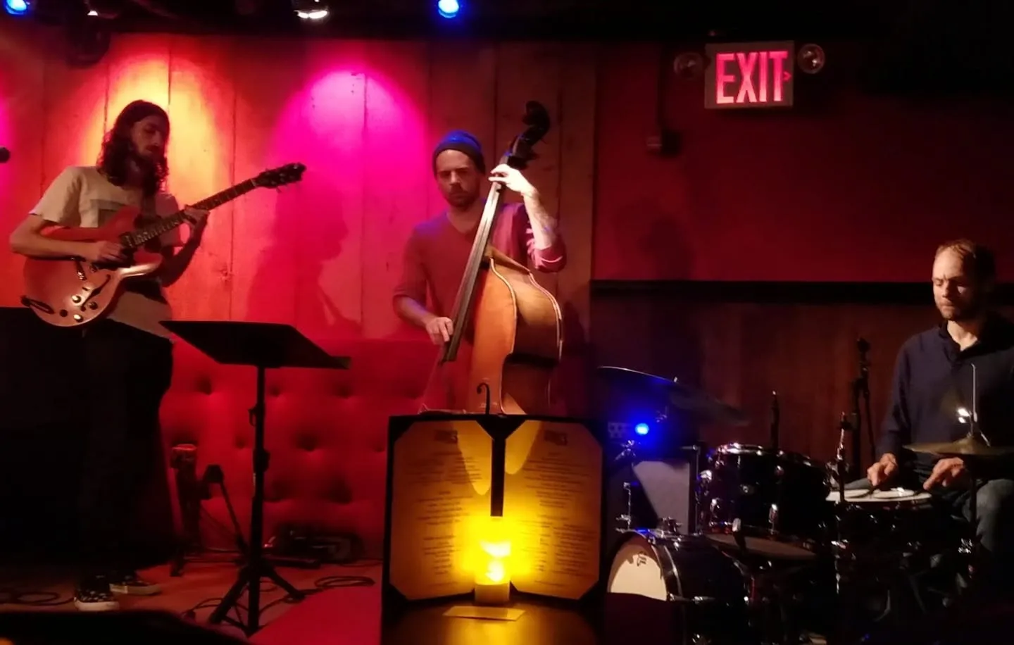 Warren Galea Trio performing in a red-lit jazz venue