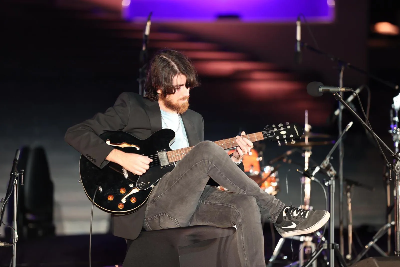 Warren Galea seated with his guitar before a performance