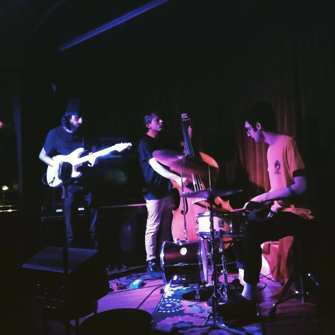 Warren Galea Trio performing on a dark stage