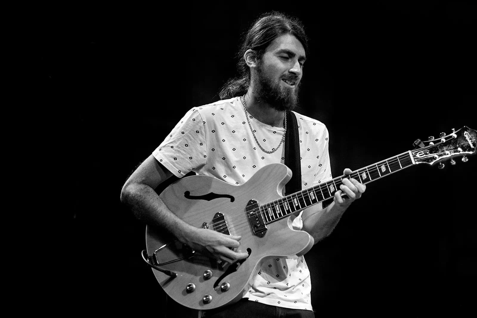 Black and white photograph of Warren Galea playing guitar