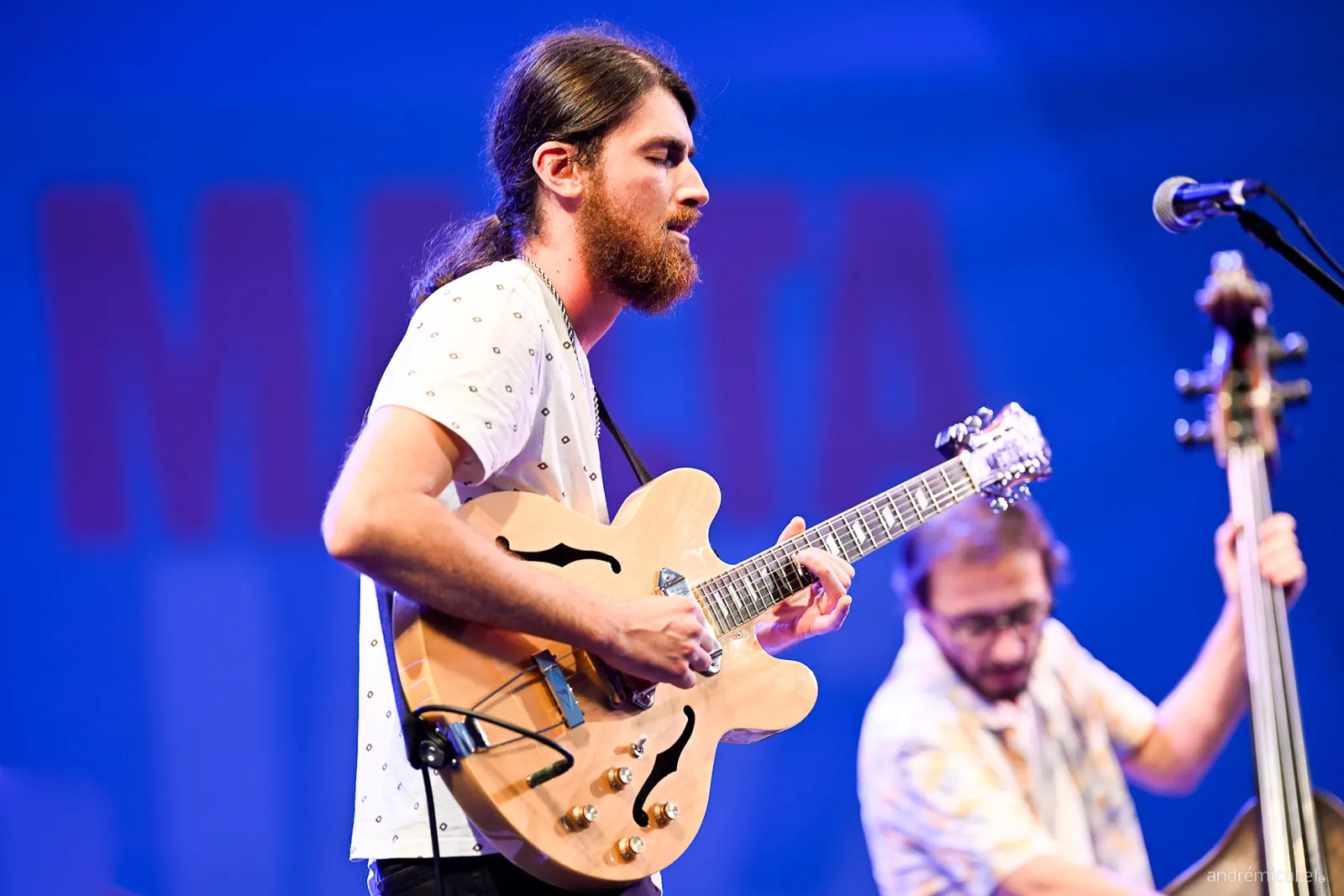 Warren Galea playing guitar on an outdoor festival stage