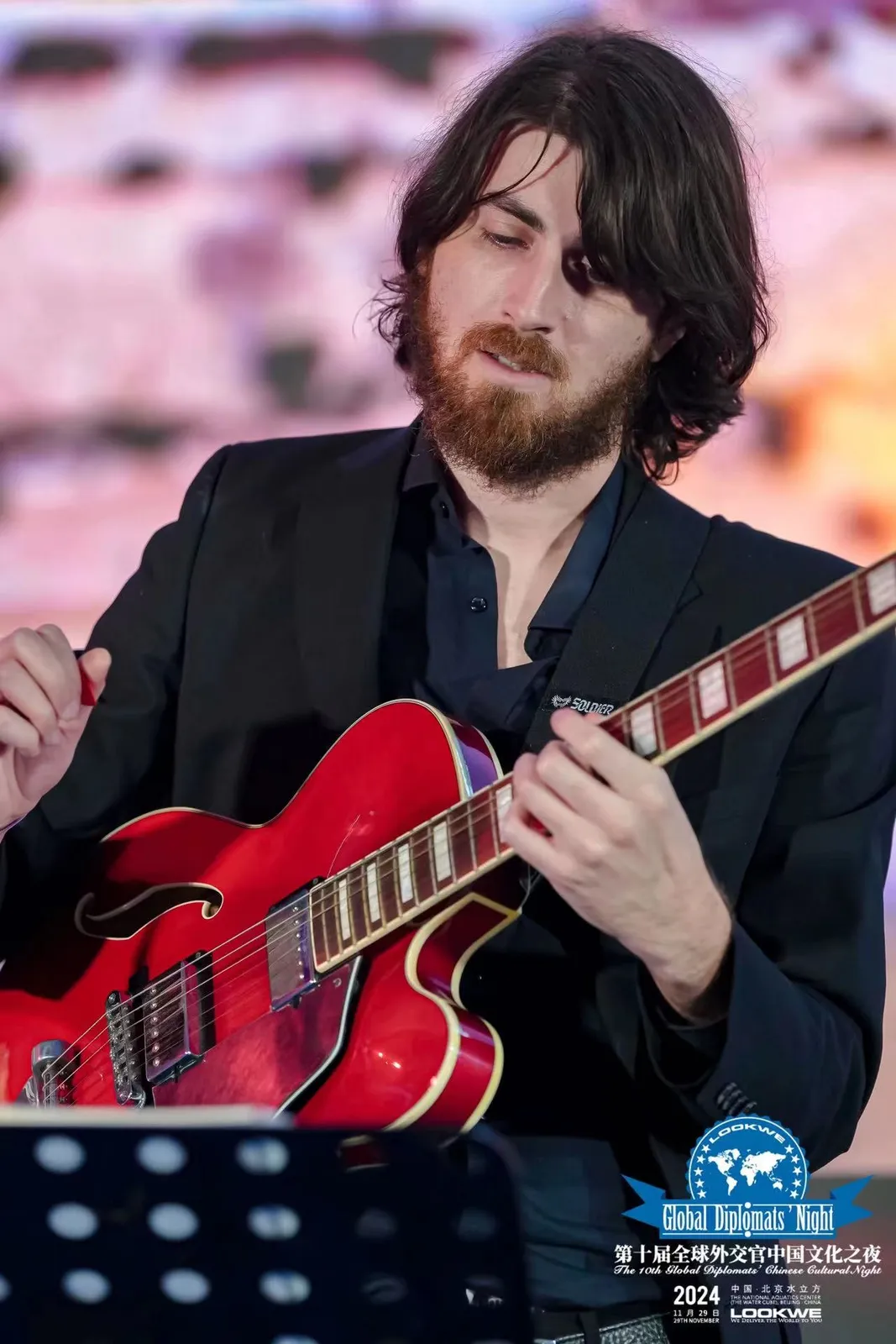 Warren Galea playing a red electric guitar at the Malta Jazz Festival